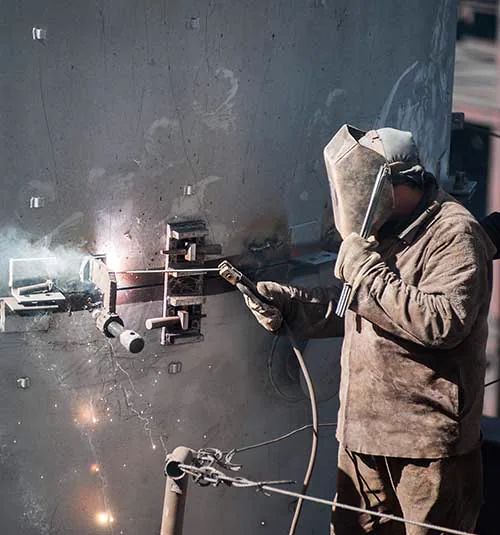 Soldador trabajando sobre la virola de un equipo de calderería